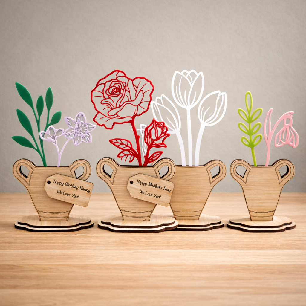 Wooden plant pots with laser-cut floral designs on a wooden surface.