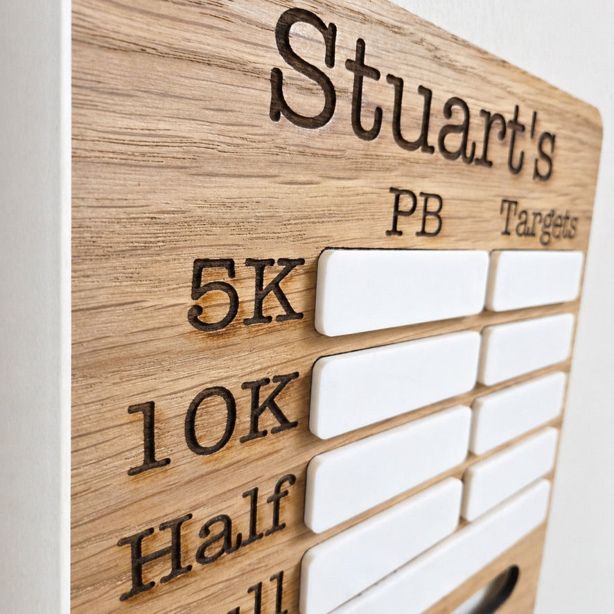     Oak veneer marathon medal display board hanging on wall