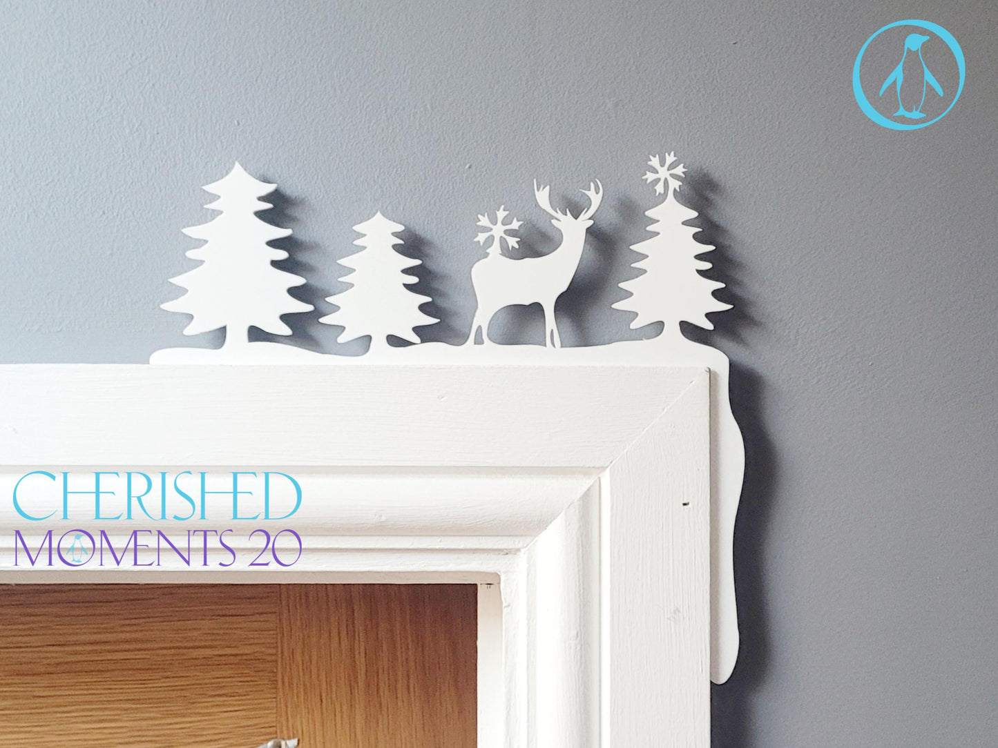 A silhouette of a reindeer and trees placed on a white door frame against a grey wall, representing a Christmas decoration.