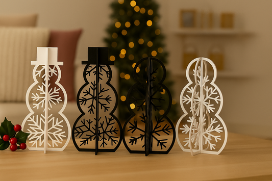 “Four freestanding snowman decorations with intricate snowflake cutouts, two in black and two in white, displayed on a wooden table in a cozy Christmas living room with soft lighting and a blurred Christmas tree in the background.”
