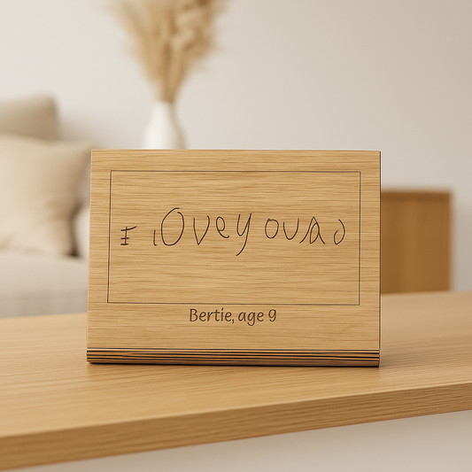 Engraved oak plaque displaying a child’s drawing with custom name and wooden stand