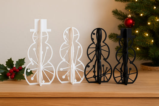 Two acrylic snowman decorations in black and white, standing upright on a wooden table with soft festive lighting. Modern 3D slot-together snowmen in small and medium sizes, perfect for Christmas and winter home decor.
