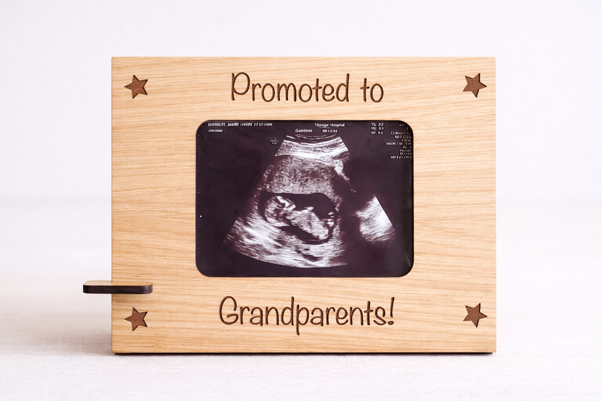 Personalised pregnancy announcement frame holding an ultrasound photo, engraved with “Promoted to Grandparents,” displayed on a wooden stand.

