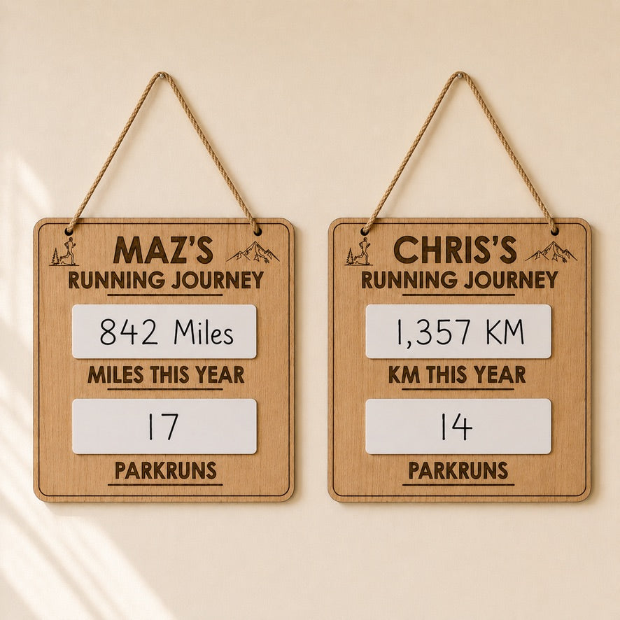 Two wooden signs tracking running journeys with distances and parkruns completed.